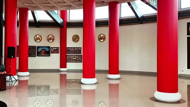 Religious altar with Buddha sculpture, offerings, and red pillars in temple interior