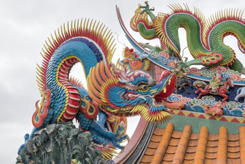 Keelung Temple,  A vibrant, colorful traditional Chinese dragon sculpture adorns the rooftop of a temple near the Zhengbin Fishing Port in keelung, Taiwan.