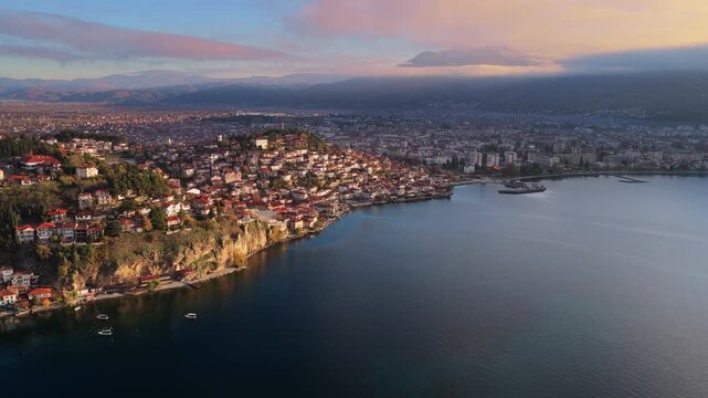 Aerial drone view of the Old Town of Ohrid, North Macedonia peninsula, its red roofed houses, and the modern part of Ohrid stretching along the lakeshore