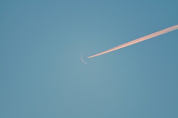 The trajectory of a jet aircraft crosses the moon