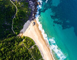 Aerial view of a stunning beach and lush green hillside with path