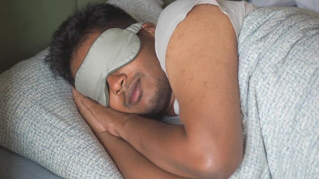 Man sleeps with eye mask in quiet bedroom setting