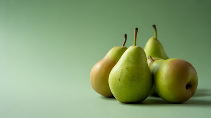 Four green pears arranged on a green background