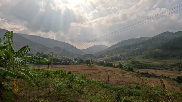 Stunning sunbeams shining over the terraced fields and rugged mountain ranges in Binh Lieu, Quang Ninh, Vietnam.
