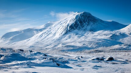 Snow-covered mountain range under a clear blue sky in winter.