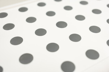 Grey polka dot pattern on white background close up. Minimalist abstract pattern for background, wallpaper, wrapping paper, or textile design.