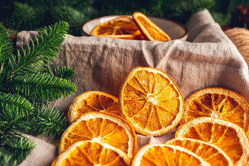 Dried orange slices and fir branches on linen cloth. Selective focus.