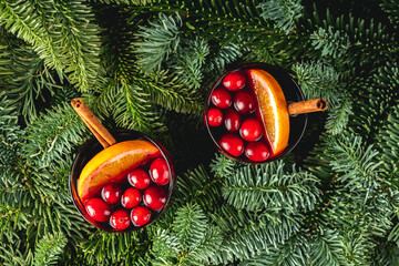 Mulled wine with orange, cranberry and cinnamon in fir forest setting. Shot from above.