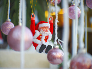 Santa Claus toy close-up on the background of a blurred Christmas tree