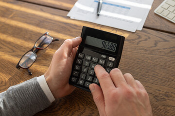 finance, close up of hands with calculator, calculating budget
