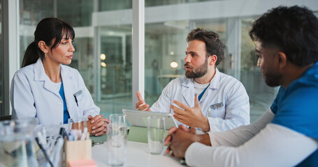 Obraz premium Meeting, team and tablet with doctors in office for medical case review, treatment plan or research. Patient history, online healthcare result and collaboration with people talking for clinic report