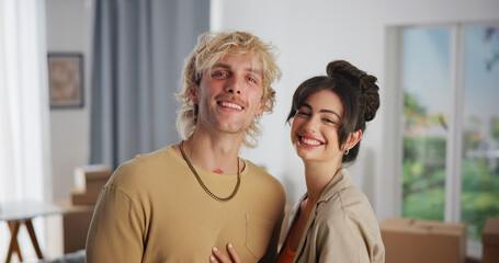 Hug, moving day and portrait of couple in living room of new home for real estate investment. Boxes, happy and love with people embracing in apartment together for growth, mortgage or property