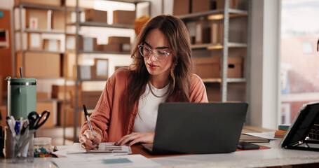 Supply chain, business and woman on laptop with notebook for planning, inventory and checklist. Office, retail supplier and person on computer for research, ecommerce and shipping for customer order © EineroLens/peopleimages.com