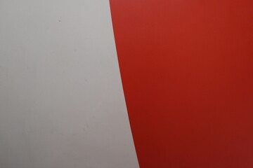 Abstract diagonal split between a clean white surface and a vibrant red background
