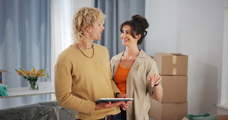 Couple, tablet and smile with boxes in new home for bonding, interior design and layout app in property. People, technology and relocation in lounge for love, real estate development or renovation
