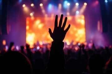 silhouetted concert audience with a raised hand reaching toward a brightly lit stage and colorful spotlights, blurred performers and an energetic euphoric atmosphere
