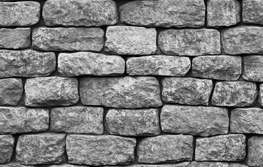 Fototapeta premium rough stacked stone wall close-up, monochrome view conveying solidity, ruggedness and timeless texture