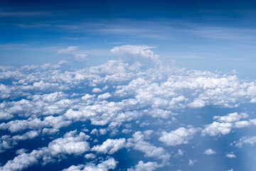 Beautiful fluffy clouds in the blue sky from an aerial perspective.