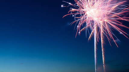 Fireworks exploding in the night sky with vibrant red and white sparks against a dark blue background