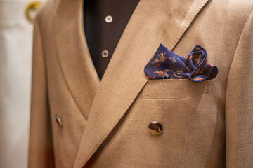 Beige double breasted blazer with pocket square, elegant menswear detail, fabric texture close up of chest pocket