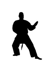 Fototapeta premium Male Martial Artist Executing a Protective Karate Block in a Defensive Stance on an Isolated White Background