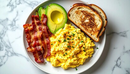 A breakfast plate with scrambled eggs crispy bacon avocado and toast on a marble surface.