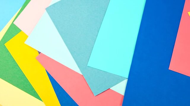 A geometric composition featuring overlapping colorful paper sheets. Variety of vivid hues create a vibrant visual