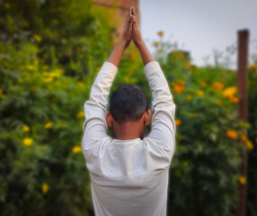 A Boy Stretching His Arms High Above His Head in a Flower Garden
