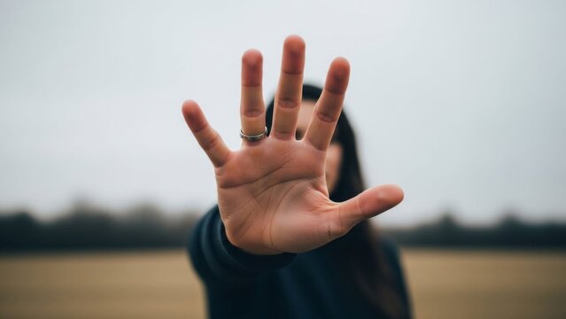 Expressive human hand gesture signaling stop or attention in a natural outdoor setting