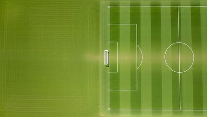 Aerial view of empty soccer field with white markings on green grass