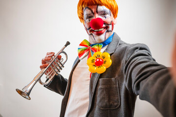 Clown smiling holding trumpet making funny selfie