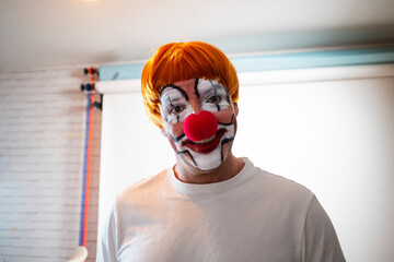 Man wearing clown makeup and wig smiling at camera