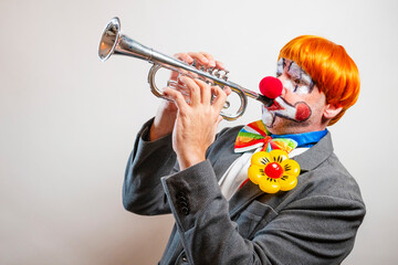 Clown playing trumpet performing comedy act