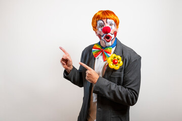 Clown entertainer pointing to side with open mouth