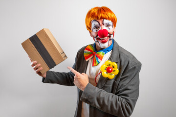 Clown delivering small brown package pointing