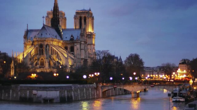 Evening View Of Notre Dame Cathedral Along The Seine In Paris At Dusk With Warm Lights