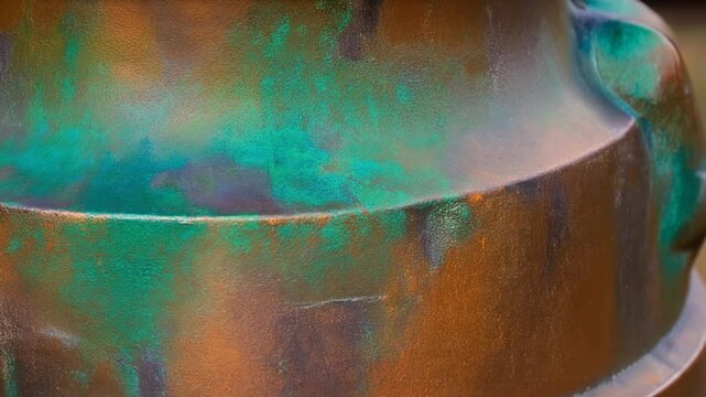 Close-up of weathered bronze with verdigris patina, textured surface