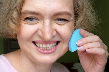 Middle-aged woman doing her morning makeup ritual at home.