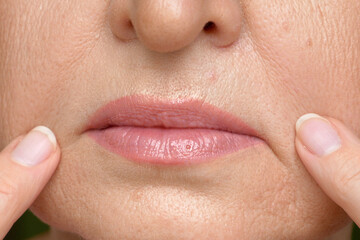 A middle-aged woman examines the expression lines on her face