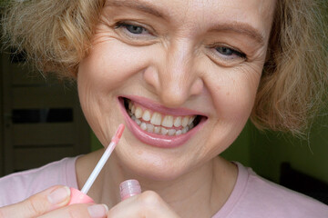 Middle-aged woman doing her morning makeup ritual at home.