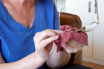 Person and cleaning vision glasses with paper wipes for lens protection, sight and eye care safety.