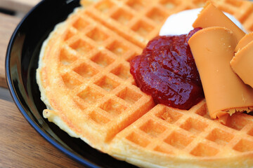 Delicious thin Nordic waffles with strawberry jam, cream and brown cheese