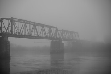 Br&uuml;cke in der Nebelstimmung &uuml;ber einem Fluss bei grauem Wetter