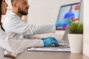 Young doctors analyzing scientific data at desk in laboratory, closeup
