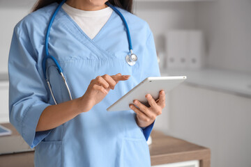 Female doctor working with tablet computer in clinic