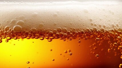 Beer bubbles and fresh foam of cold alcoholic drink. Closeup of foamy lager beer in glass macro