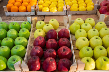 Market crates filled with fresh apples at an outdoor produce stand, showcasing abundant harvest and vibrant agricultural abundance in a rustic setting.

