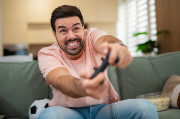 Excited man playing video game on couch