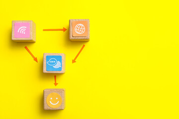 Connected cubes with smile and networking symbols on yellow background. Link concept