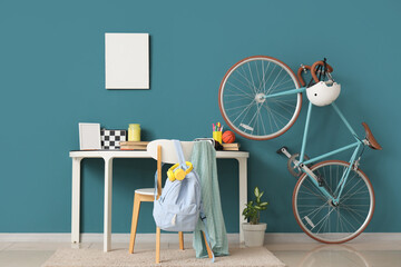 Interior of teenager's room with workplace, blank frames and bicycle